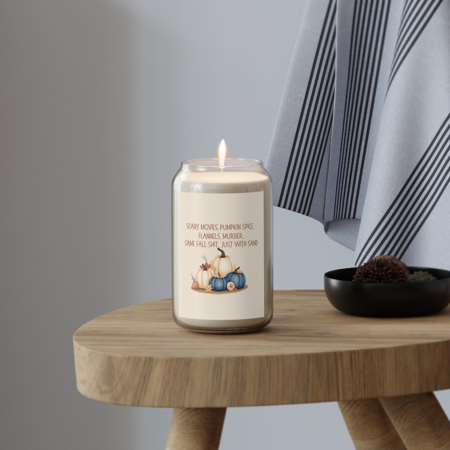 Candle with a label on a wooden table against a neutral background