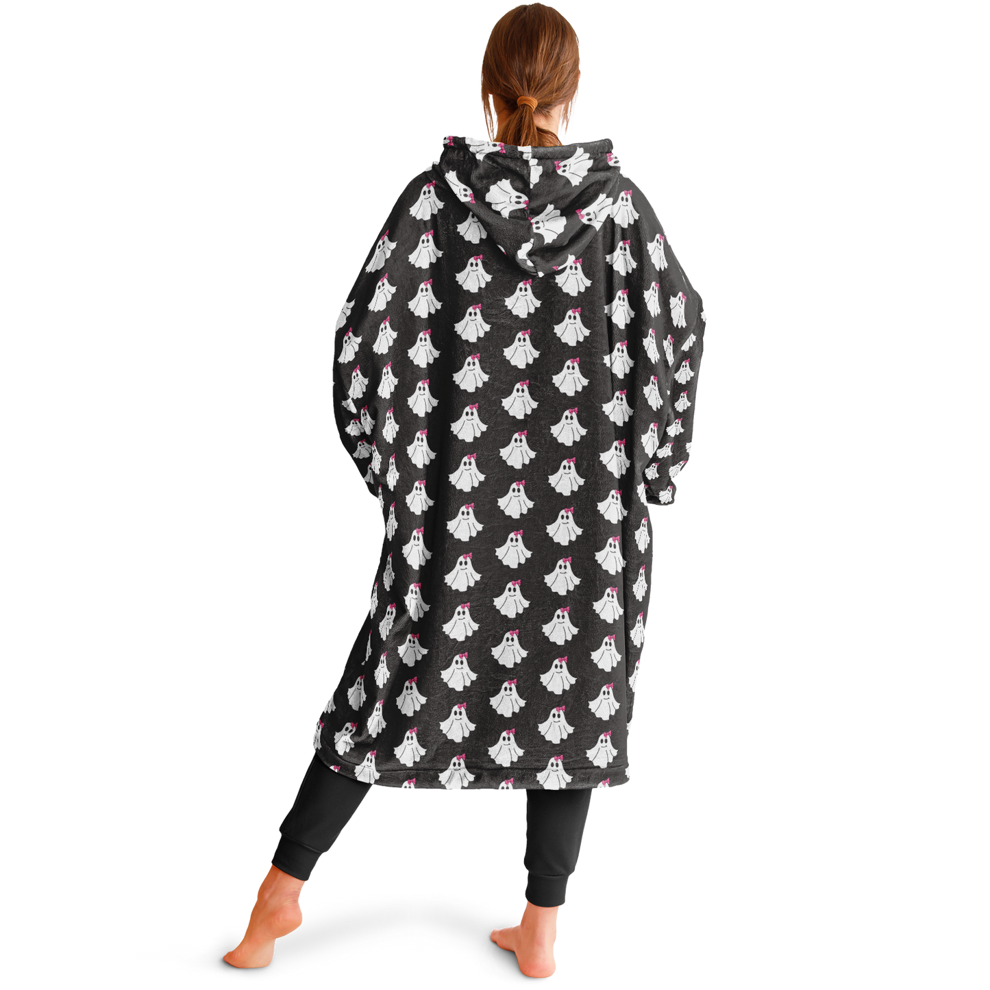 Person wearing a black poncho with ghost patterns on a white background