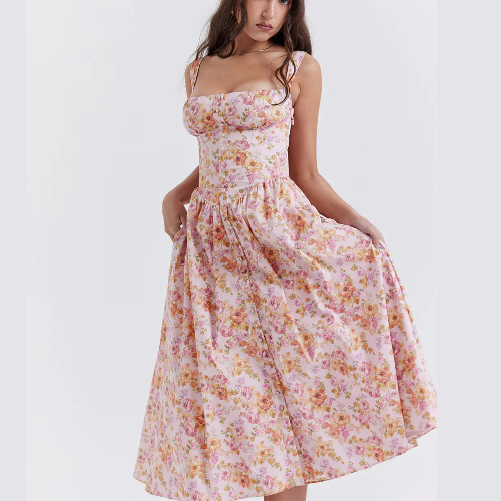 Woman wearing a pink floral summer midi dress with fitted bodice
