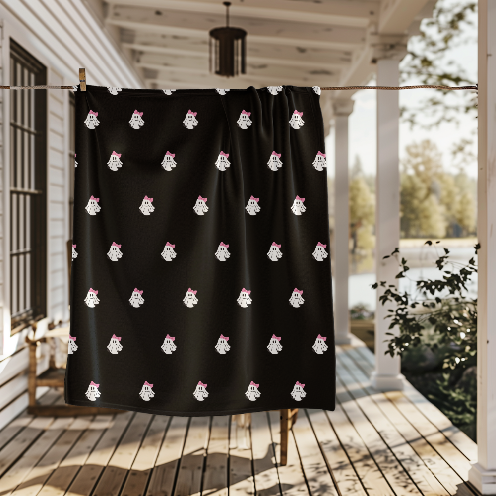 Black Blanket with white ghost pattern on a wooden porch