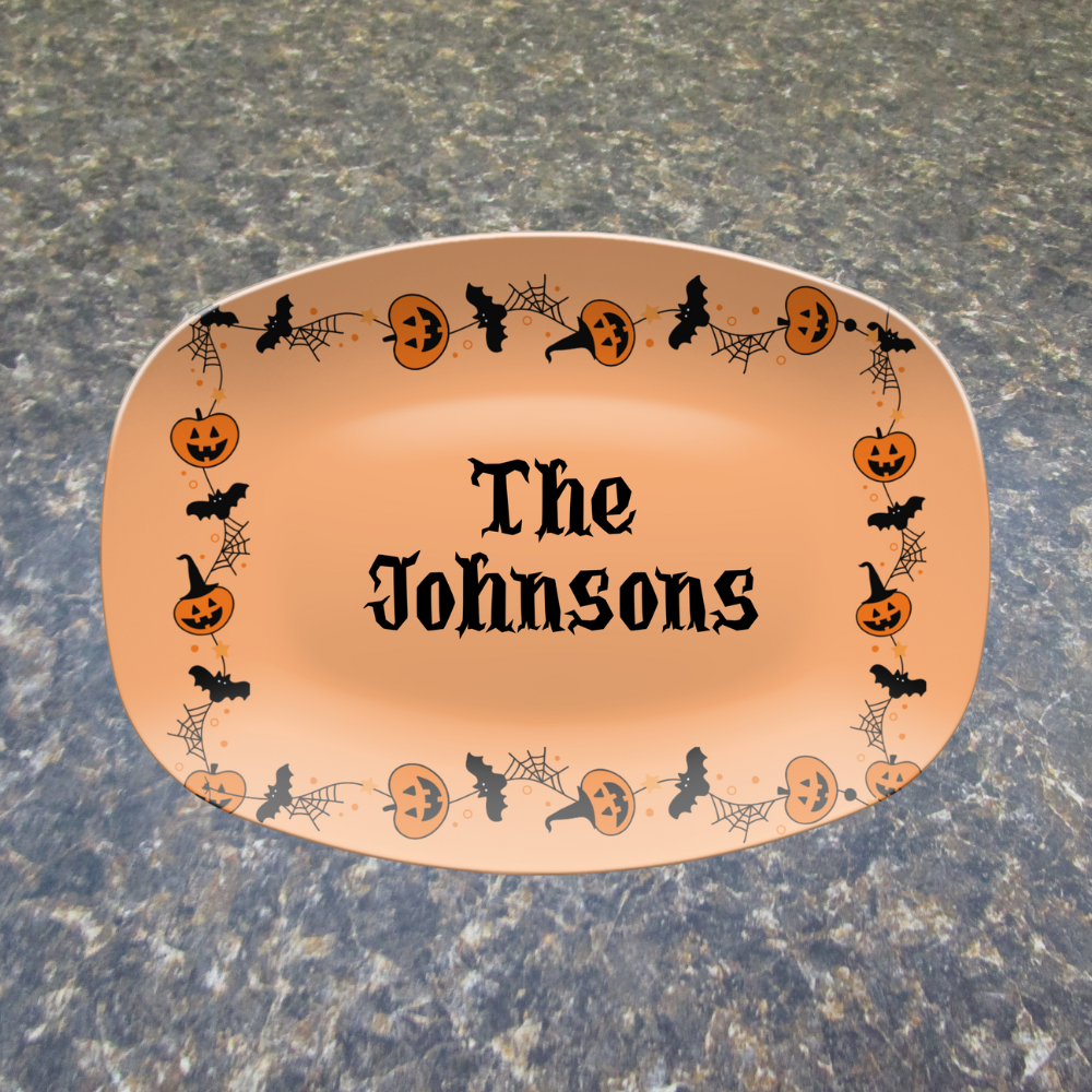 Decorative plate with Halloween-themed design and 'The Johnsons' text on a stone surface.