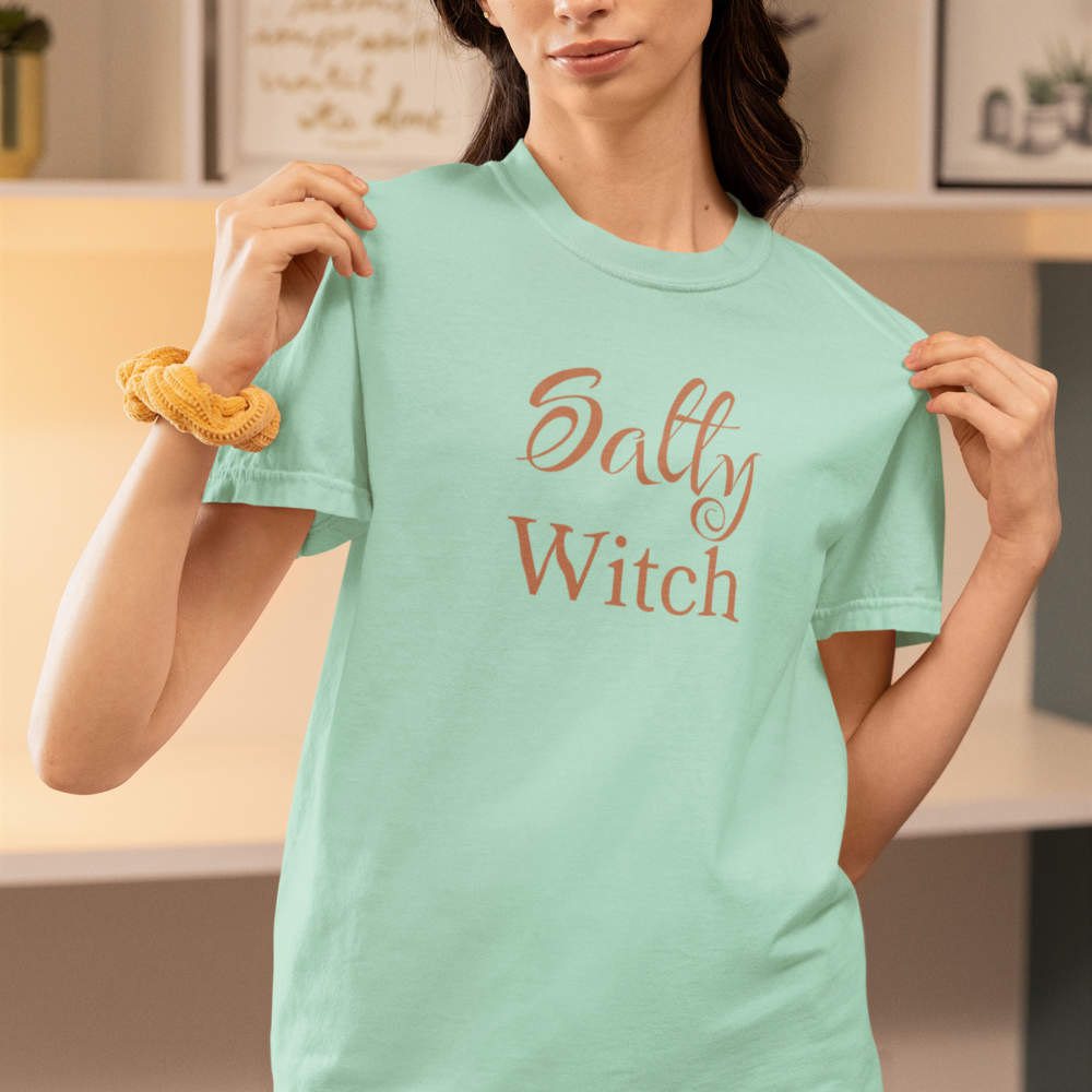 Person wearing a light green t-shirt with 'Salty Witch' text in a casual setting.