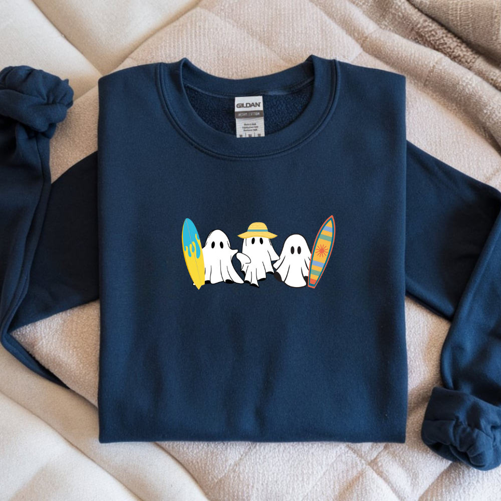 Navy blue sweatshirt with ghost and surfboard design on a beige blanket