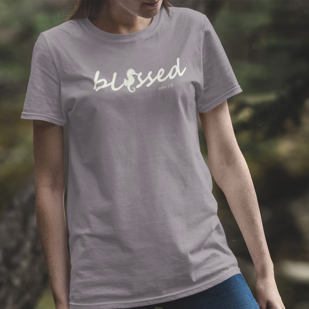 Person wearing a gray t-shirt with 'blessed' printed on it, standing outdoors.