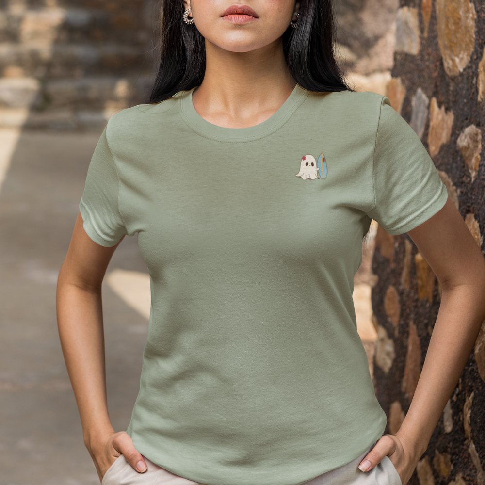 Person wearing a green t-shirt with a small graphic on a stone wall background