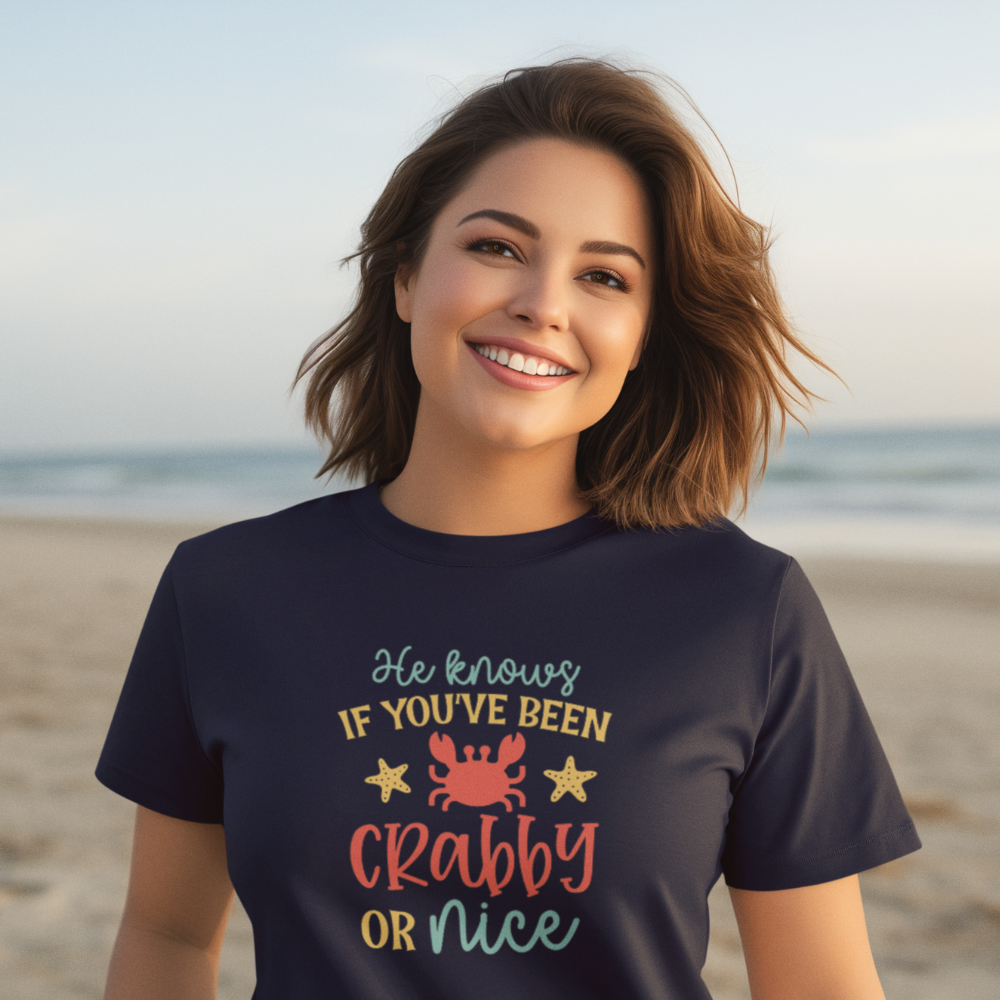 Woman wearing a t-shirt with a beach-themed design on a sandy beach.