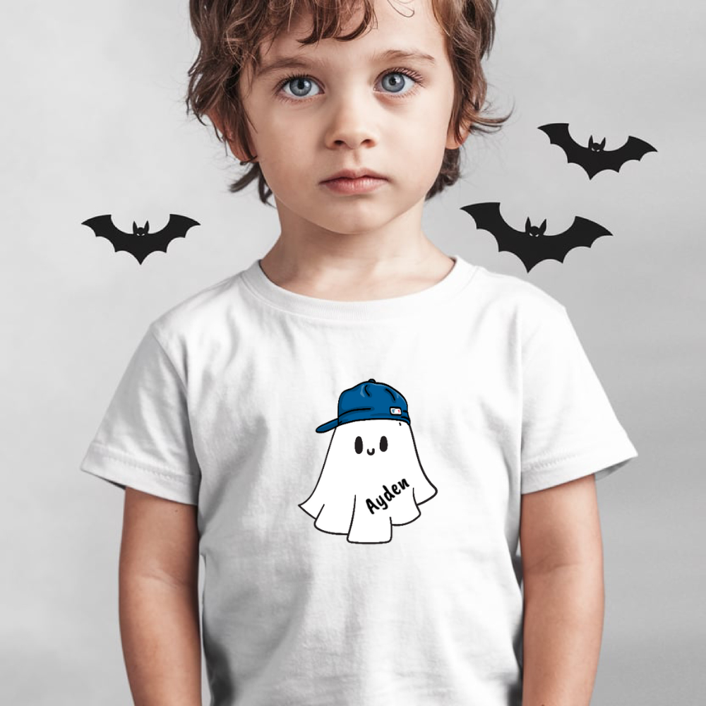 Child wearing a white t-shirt with a ghost graphic and blue cap, surrounded by black bat illustrations on a light gray background.