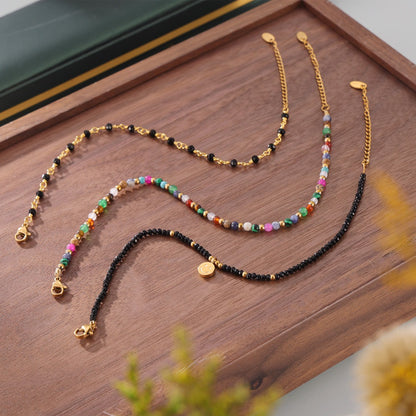 Elegant gold anklets with black gem beads styled on ankle