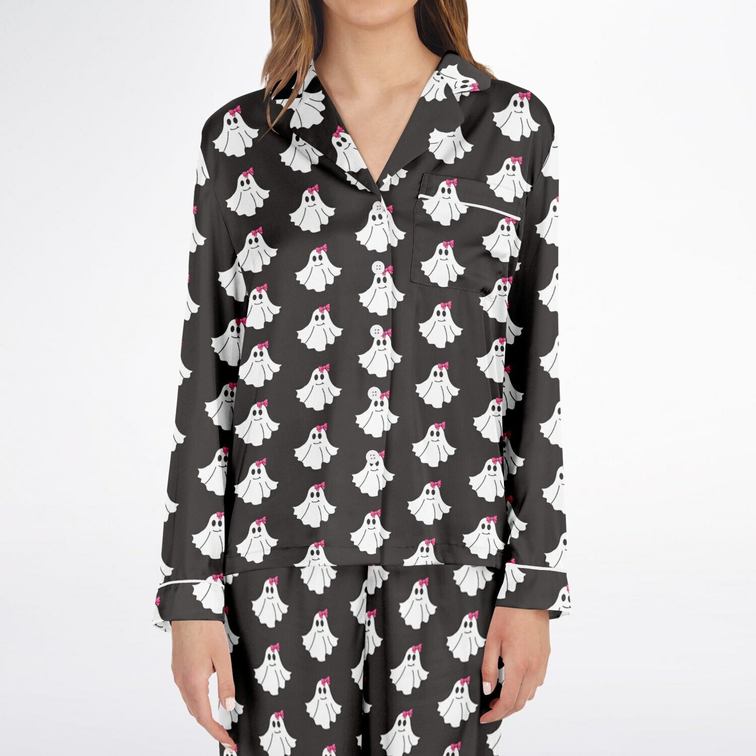 Black pajama top with ghost pattern worn by a person on a white background
