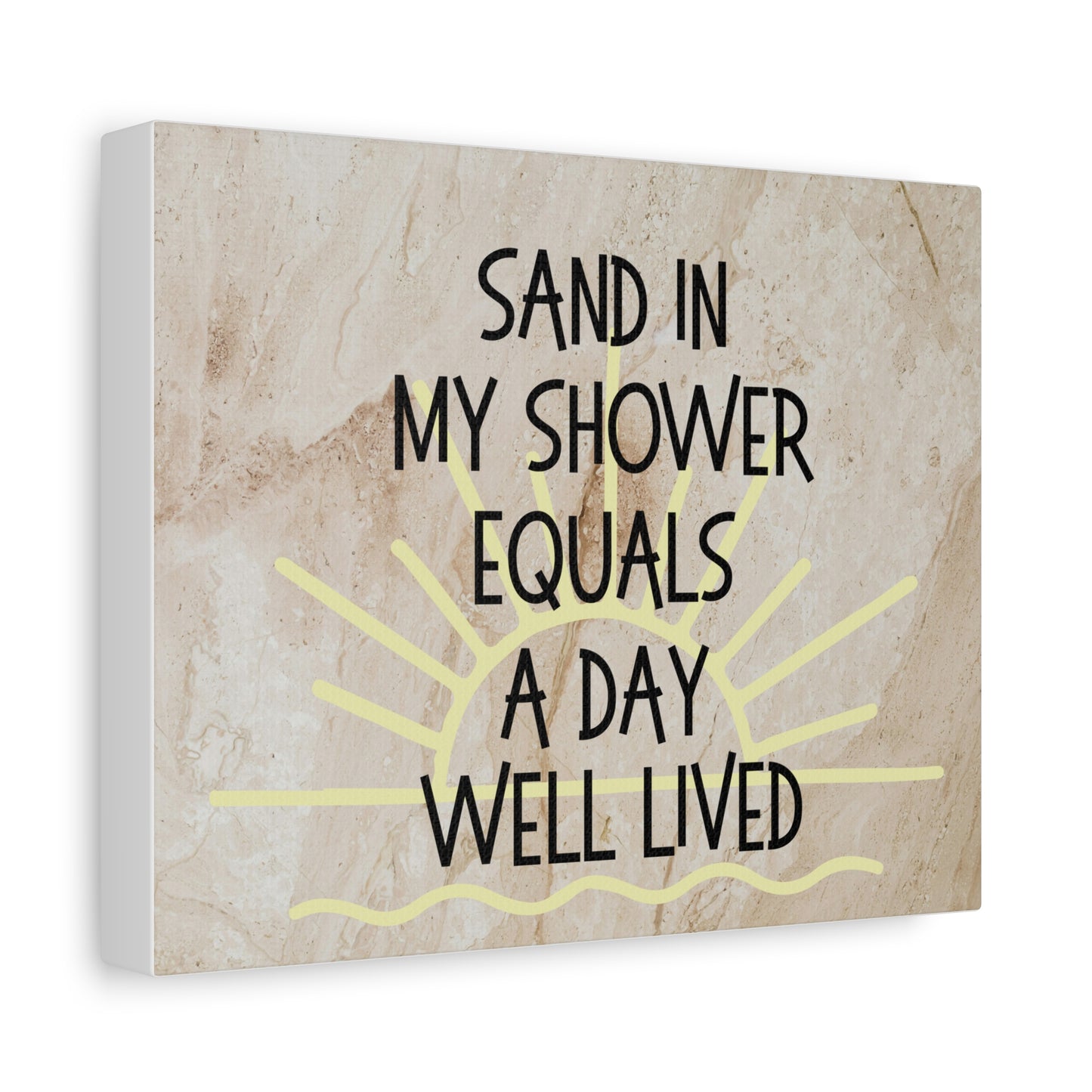 Canvas print with text 'Sand in my shower equals a day well lived' on a textured beige background.