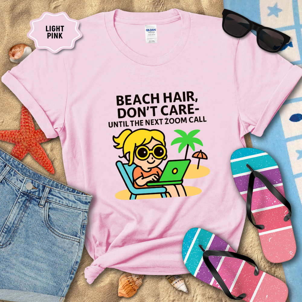 Light pink t-shirt with beach-themed graphic and text, surrounded by beach accessories.