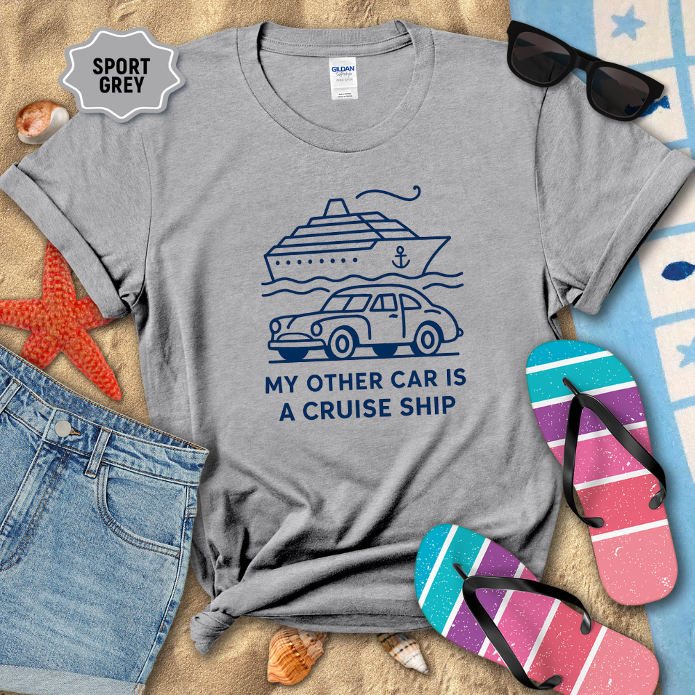 Gray t-shirt with a cruise ship and car graphic and text, surrounded by beach items.
