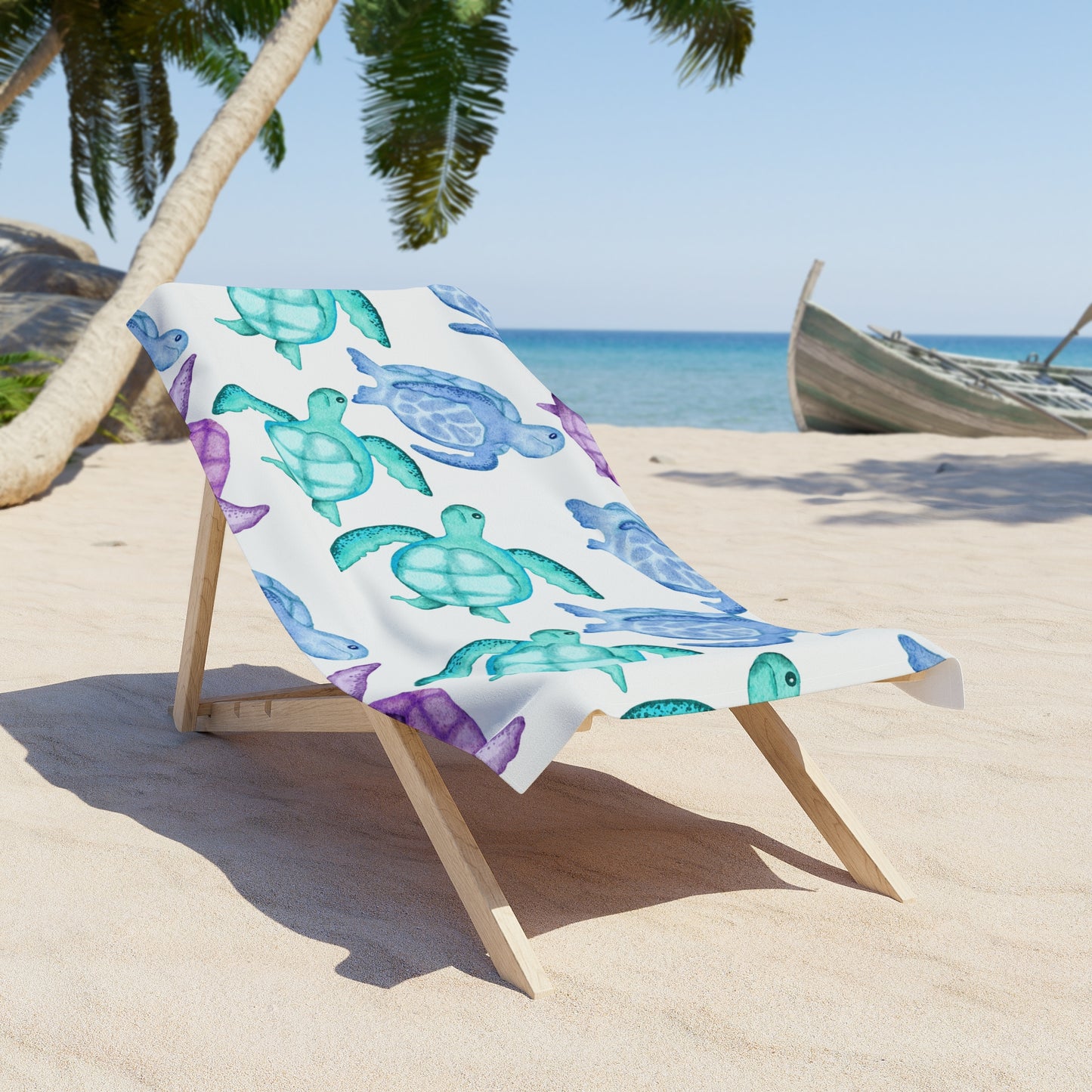 Beach chair with a colorful turtle-patterned towel on a sandy beach with palm trees and ocean in the background.