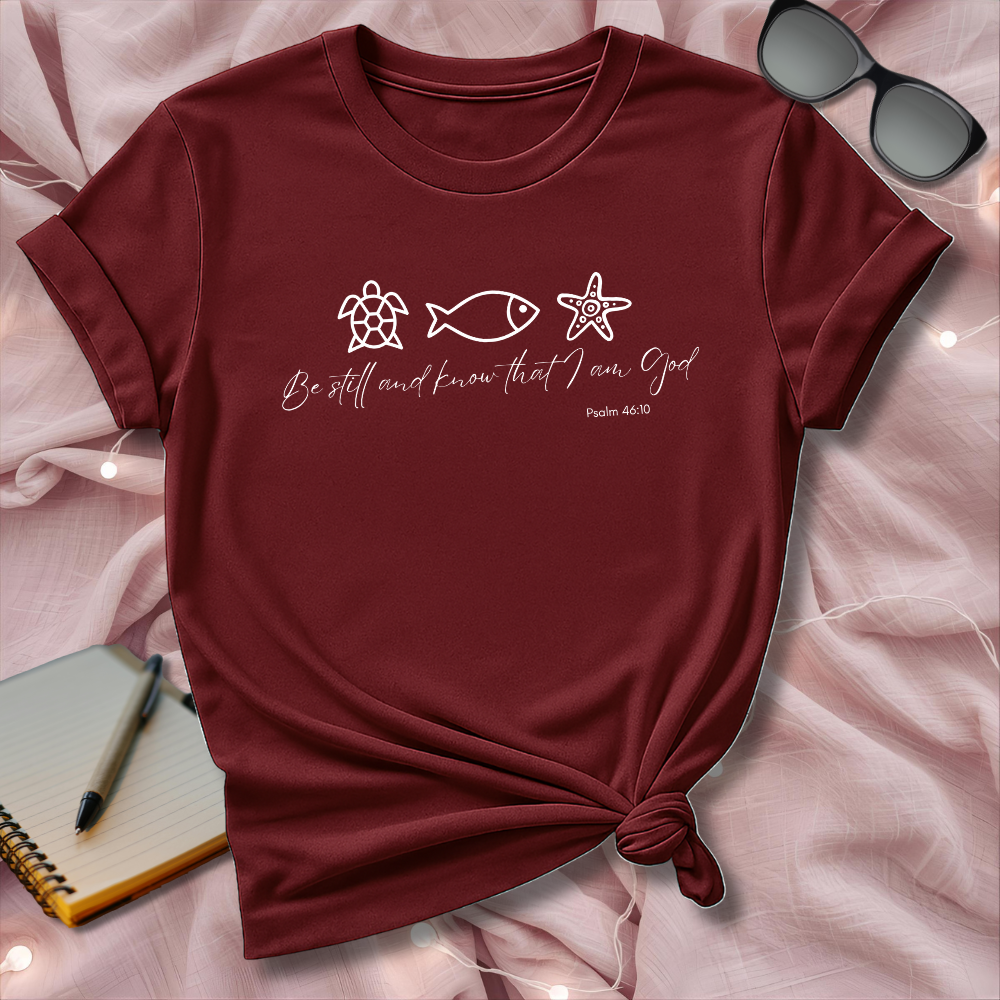 Maroon t-shirt with religious text and symbols on a pink fabric background