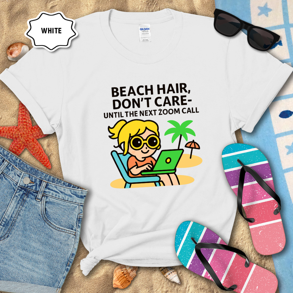 White t-shirt with beach-themed design and text, surrounded by beach items on sand.