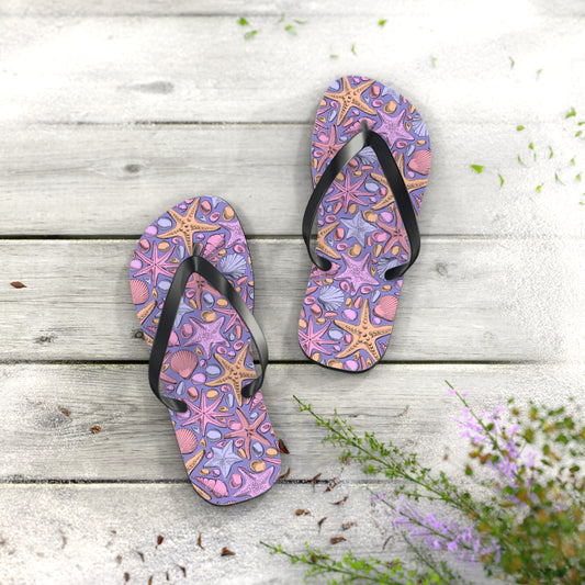Pair of purple flip-flops with starfish design on a wooden surface.