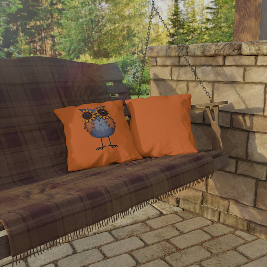 Wooden porch swing with plaid blanket and orange pillows against a stone wall and greenery background