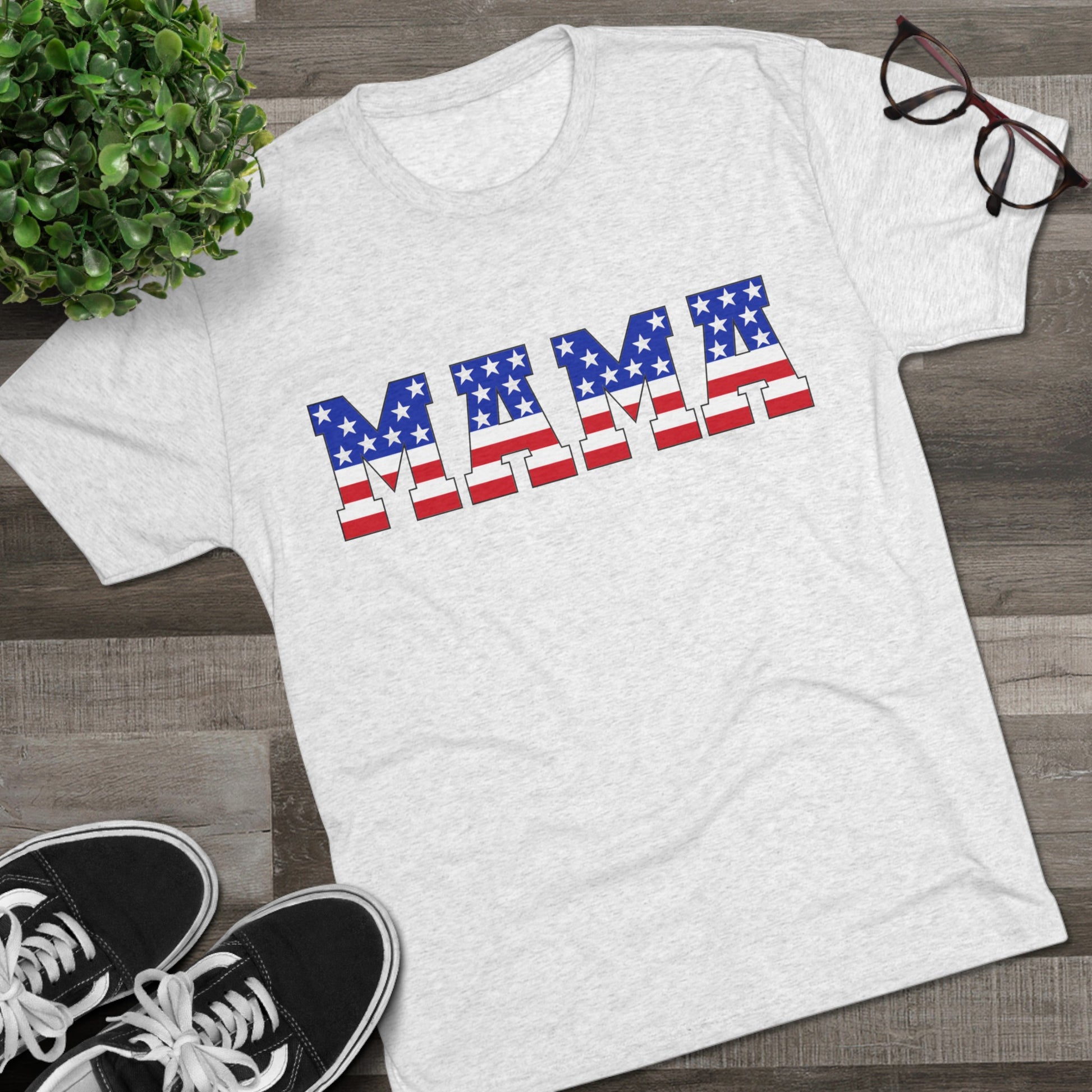 White heatered T-shirt with “MAMA” in American flag print across the chest, showcasing a patriotic and stylish design.