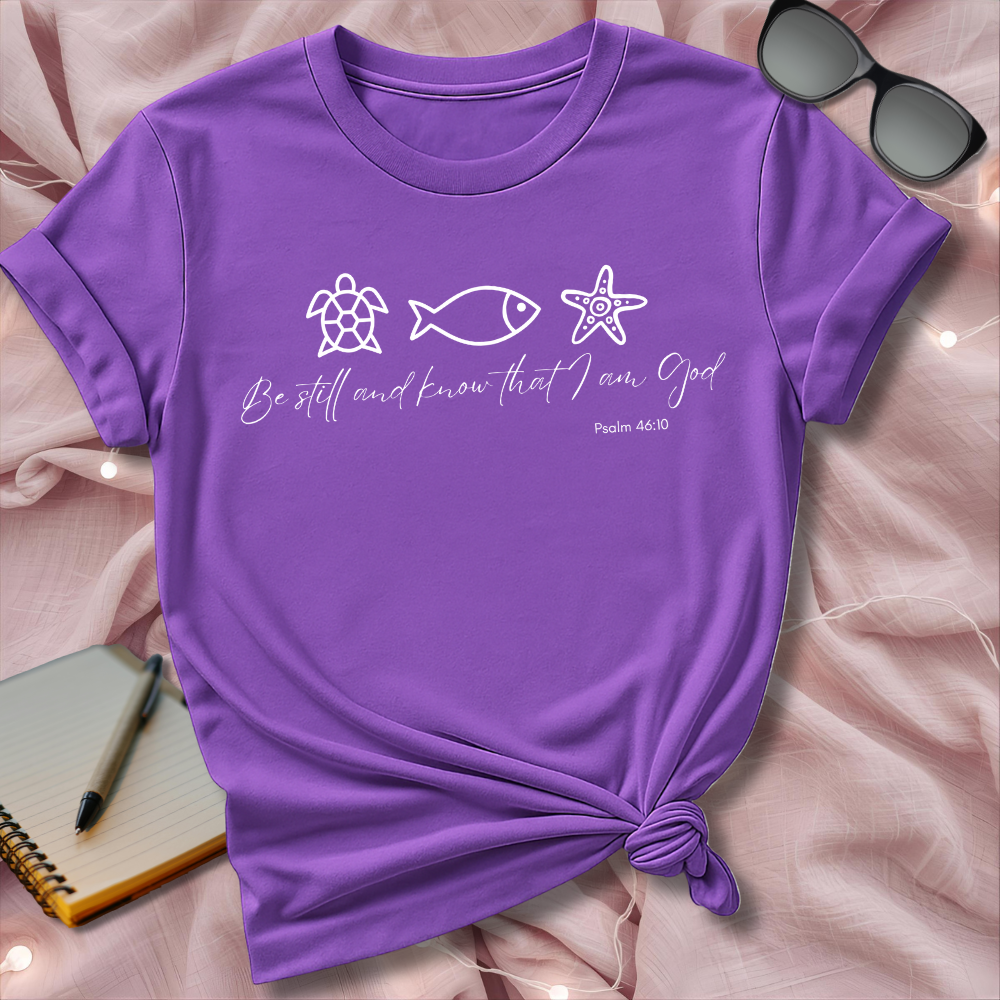 Purple t-shirt with religious text and symbols on a pink surface