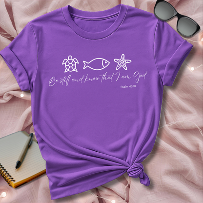 Purple t-shirt with religious text and symbols on a pink surface