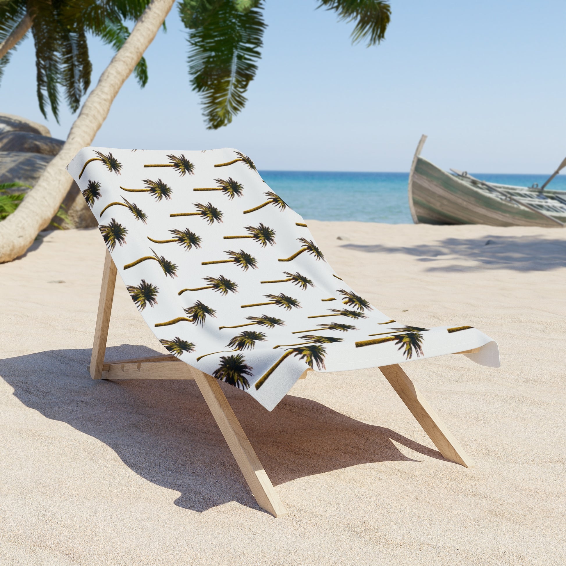 Beach towel with palm tree pattern on a wooden stand on a sandy beach.