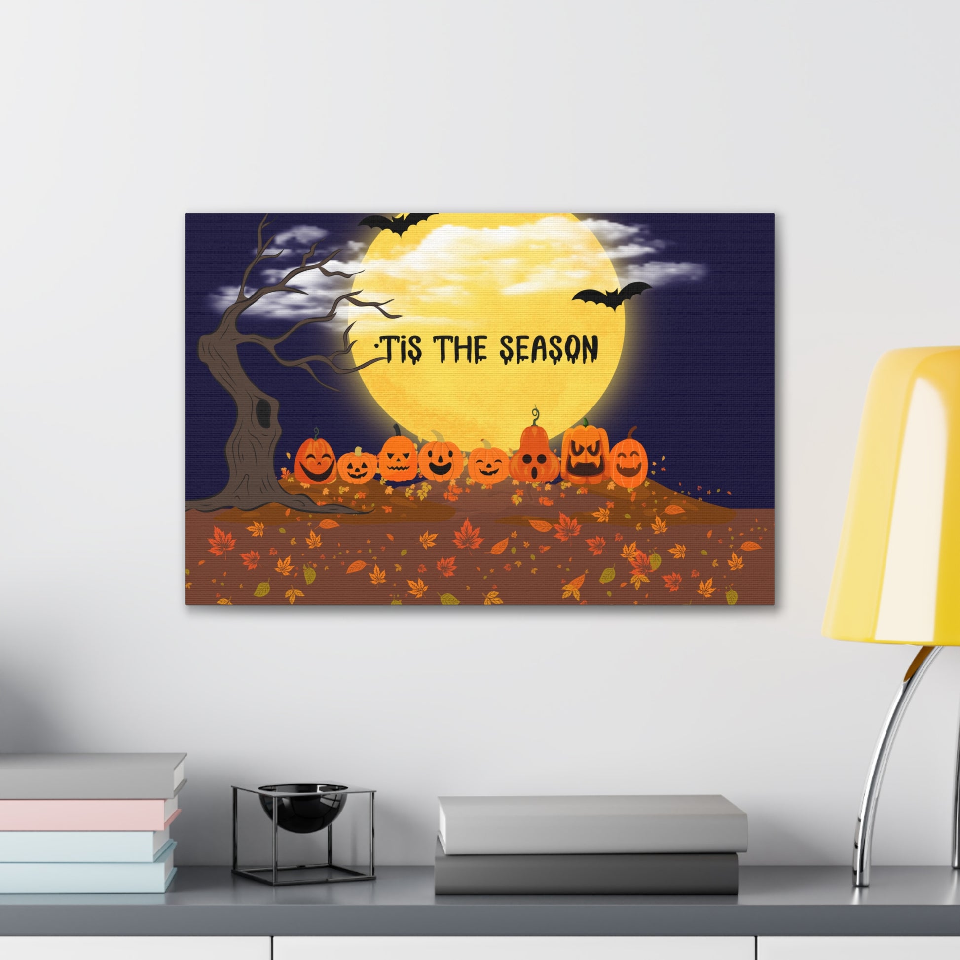 Halloween-themed wall art with pumpkins and full moon on a white wall.