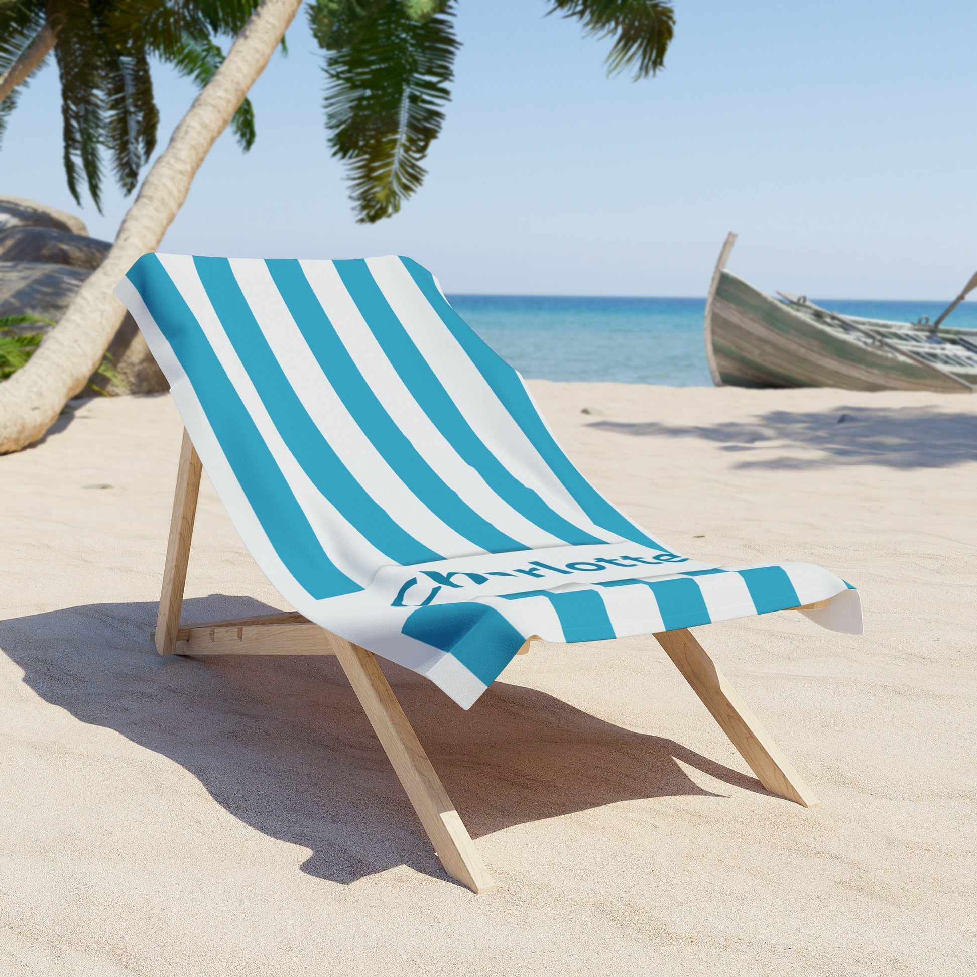Beach chair with a blue and white striped towel on a sandy beach with palm trees and ocean in the background.