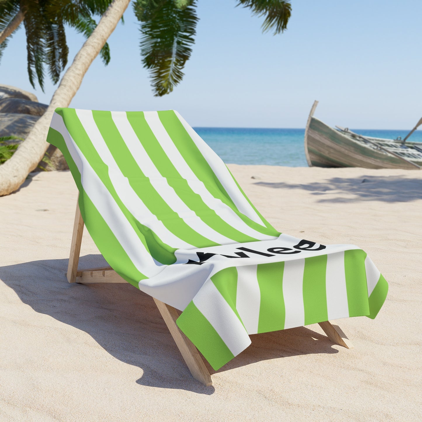 Green and white striped towel on a beach chair with palm trees and ocean in the background