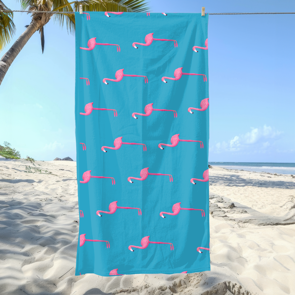 Blue towel with pink flamingo pattern hanging on a beach
