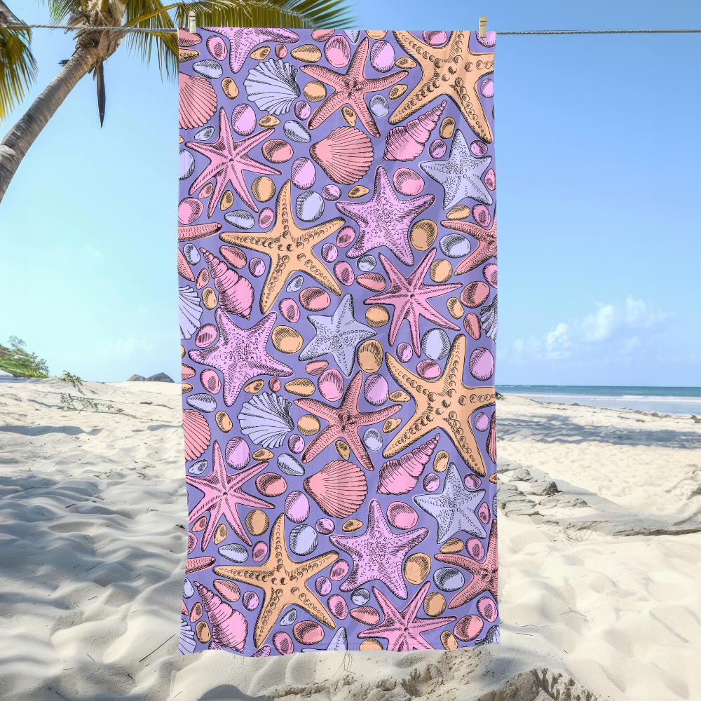 Colorful beach towel with starfish and shell pattern on a sandy beach.