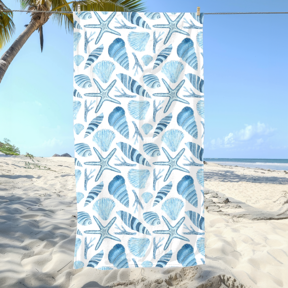 Beach towel with blue shell and starfish pattern on a beach