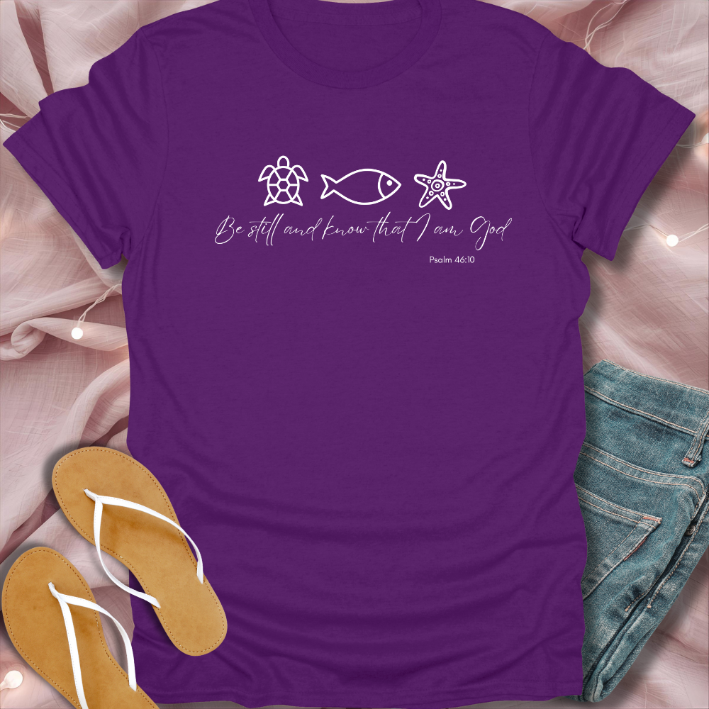 Purple t-shirt with nature-themed design and text on a soft pink fabric background