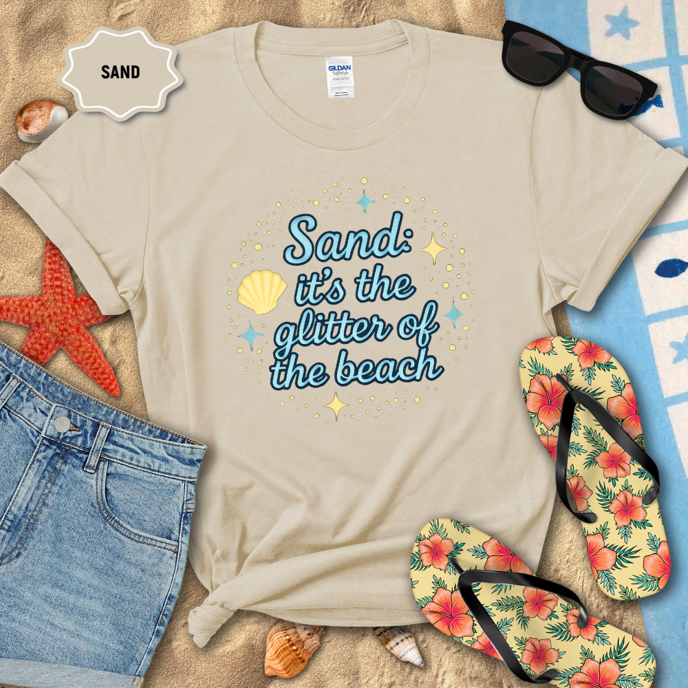 Beige t-shirt with beach-themed text on sand with sunglasses, flip-flops, and starfish.