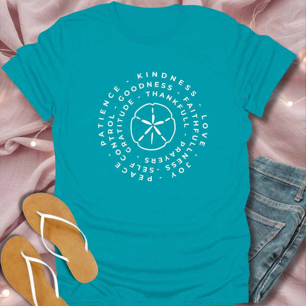 Teal t-shirt with motivational text and symbols on a pink fabric background
