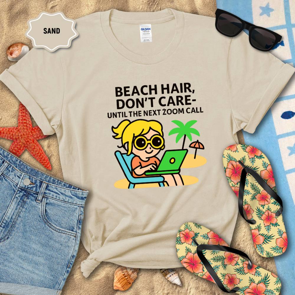 Beige t-shirt with beach-themed design and text on sand with flip-flops and sunglasses.