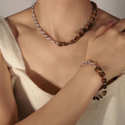 Close-up of polished tiger eye gemstone bracelet on cream velvet tray

