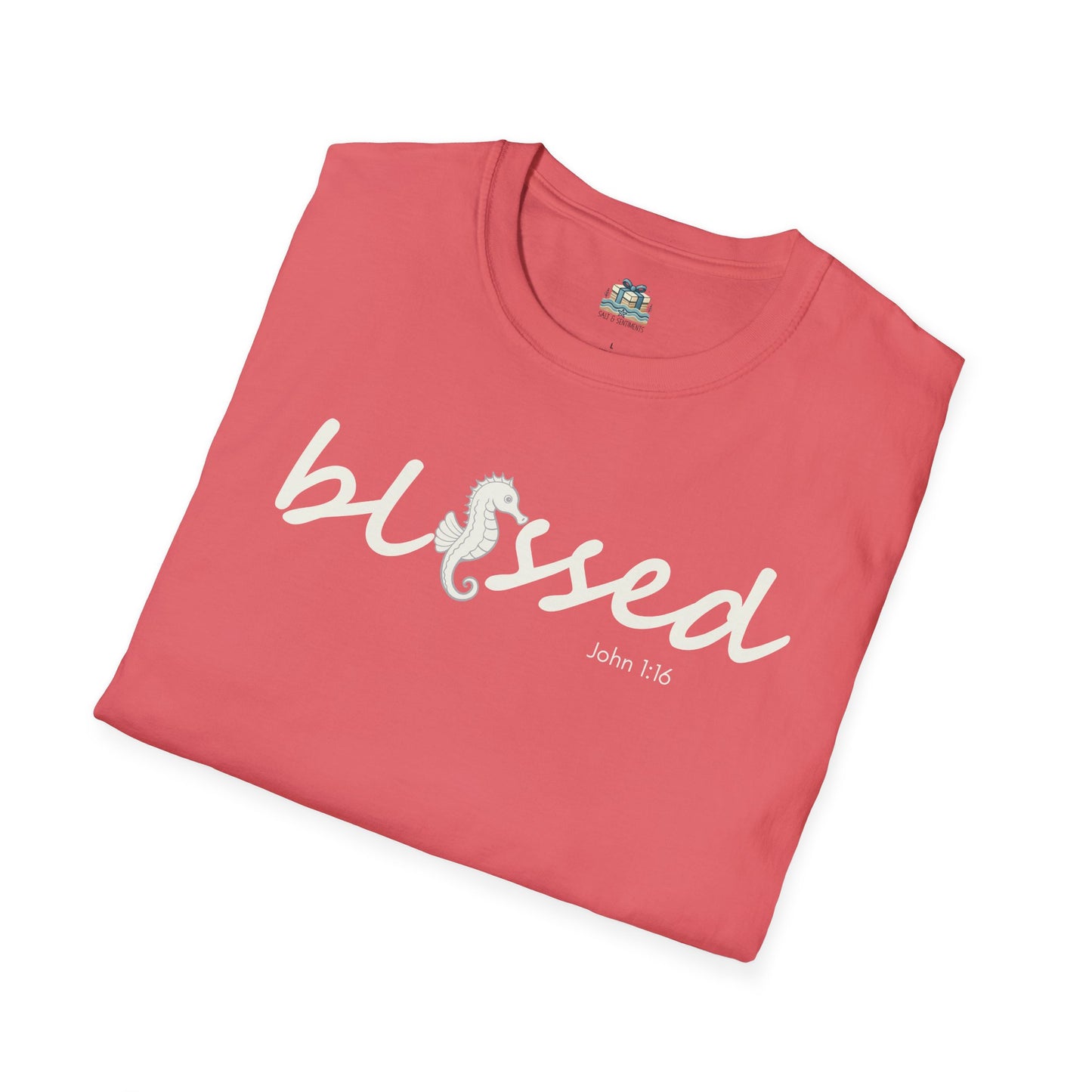 Folded pink t-shirt with 'blessed' text on a white background