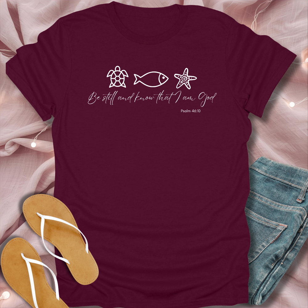Maroon t-shirt with religious text and symbols on a pink fabric background