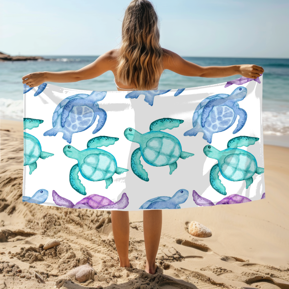 Person holding a towel with turtle pattern on a beach