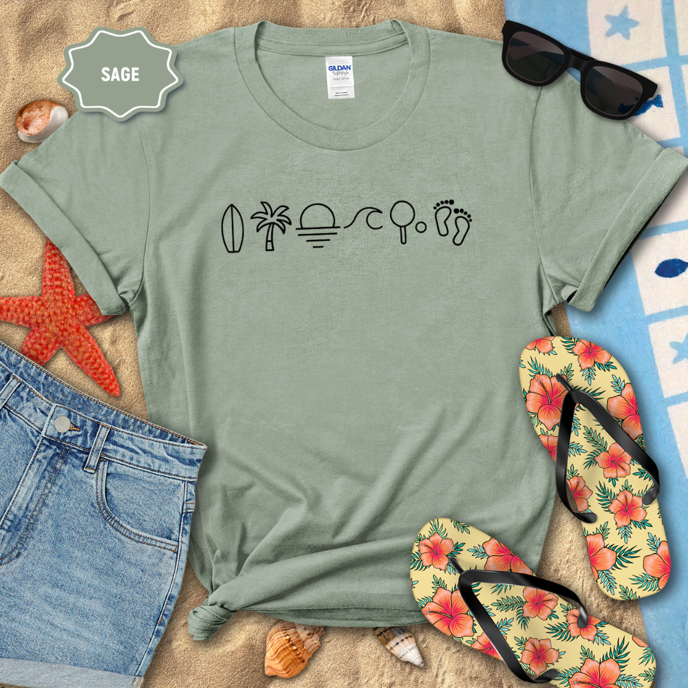 Sage green t-shirt with beach-themed icons on a sandy surface with flip-flops and sunglasses.