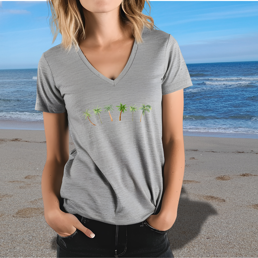 Person wearing a gray t-shirt with palm tree design on a beach