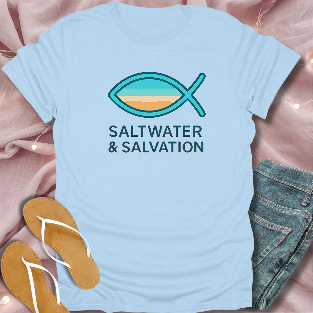 Light blue t-shirt with fish symbol and 'Saltwater & Salvation' text, paired with flip-flops and jeans on a pink fabric background.