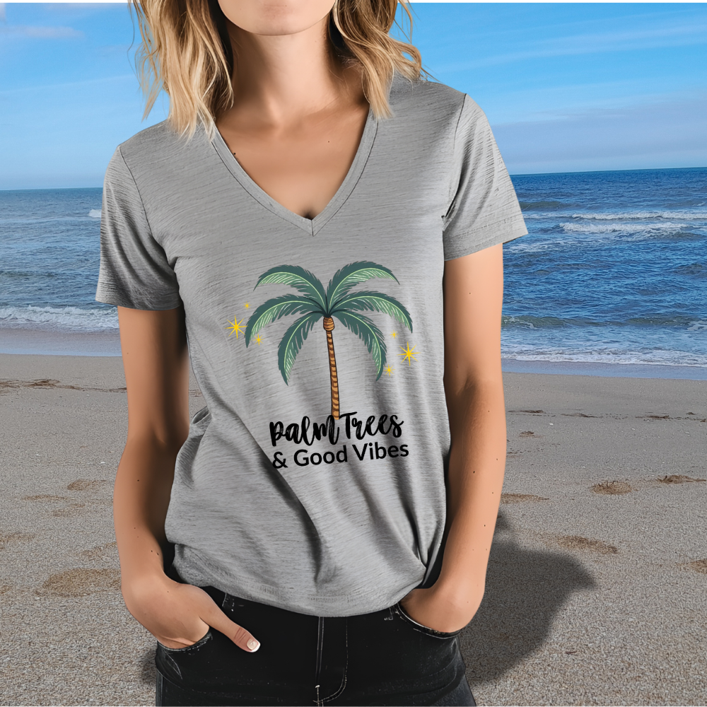 Person wearing a gray t-shirt with a palm tree design and 'Palm Trees & Good Vibes' text on a beach.