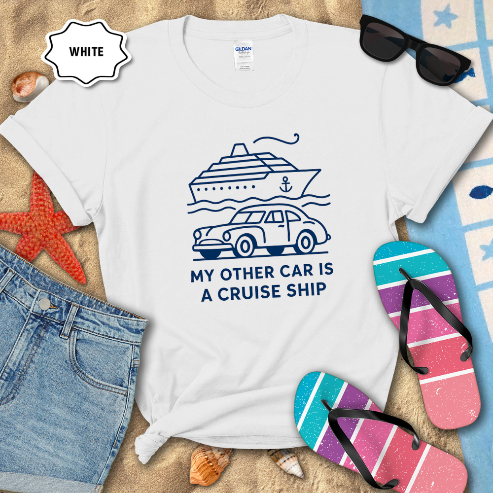 White t-shirt with a graphic design and text on a sandy background with flip-flops and sunglasses.