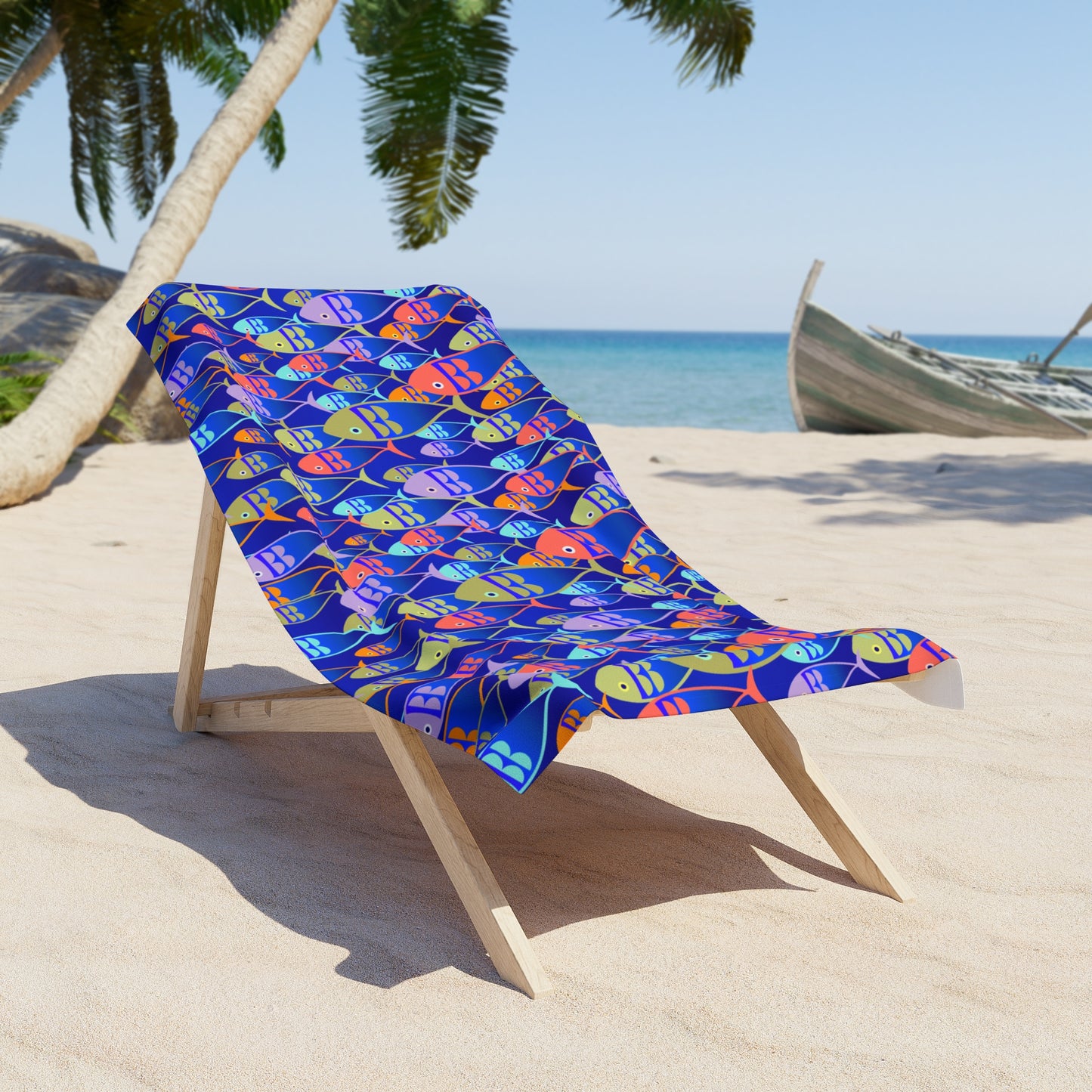 Colorful fish-patterned towel on a wooden beach chair with a tropical background