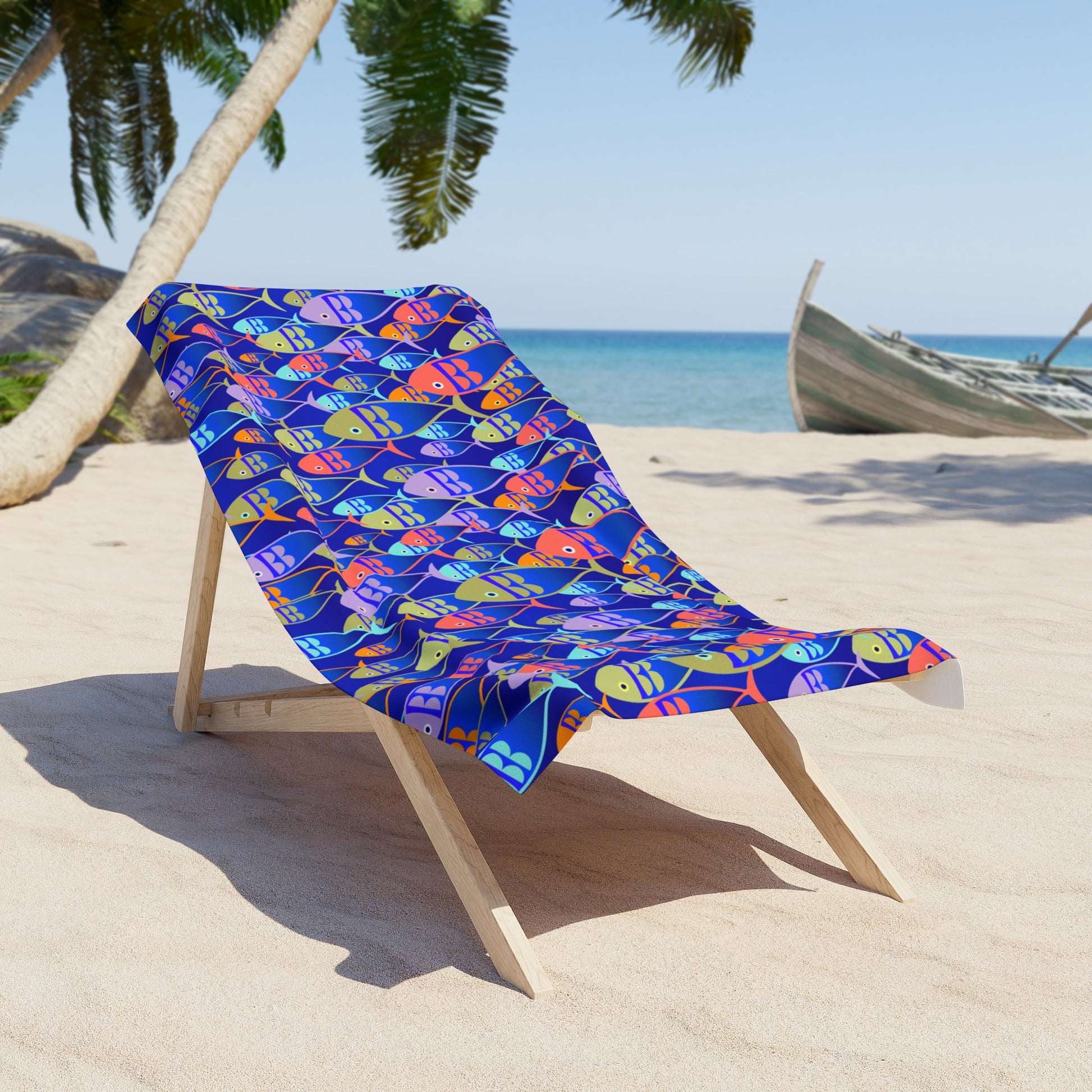 Colorful fish-patterned towel on a wooden beach chair with a tropical background