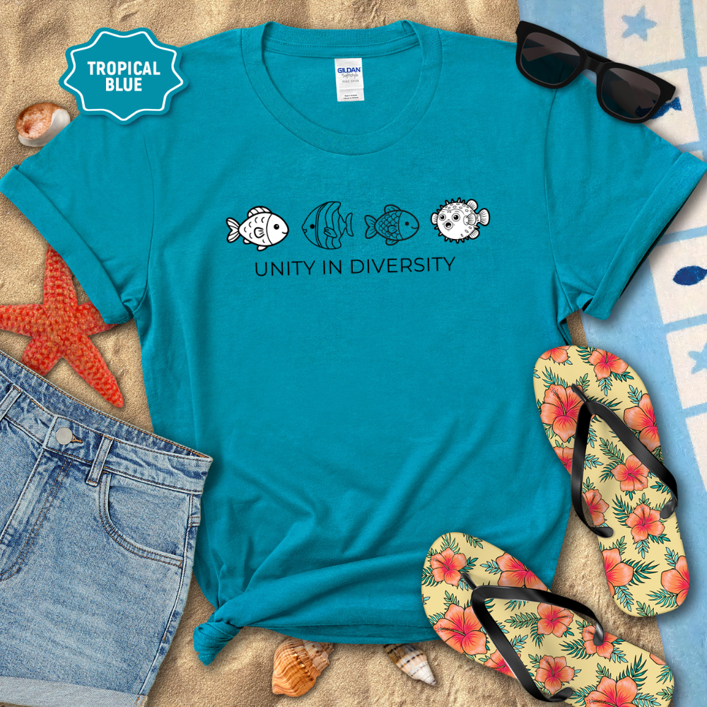 Blue t-shirt with fish design and 'Unity in Diversity' text on a beach setting with sunglasses, flip-flops, and shorts.
