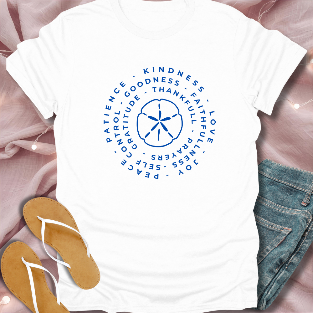 White t-shirt with blue circular design and text on a pink fabric background