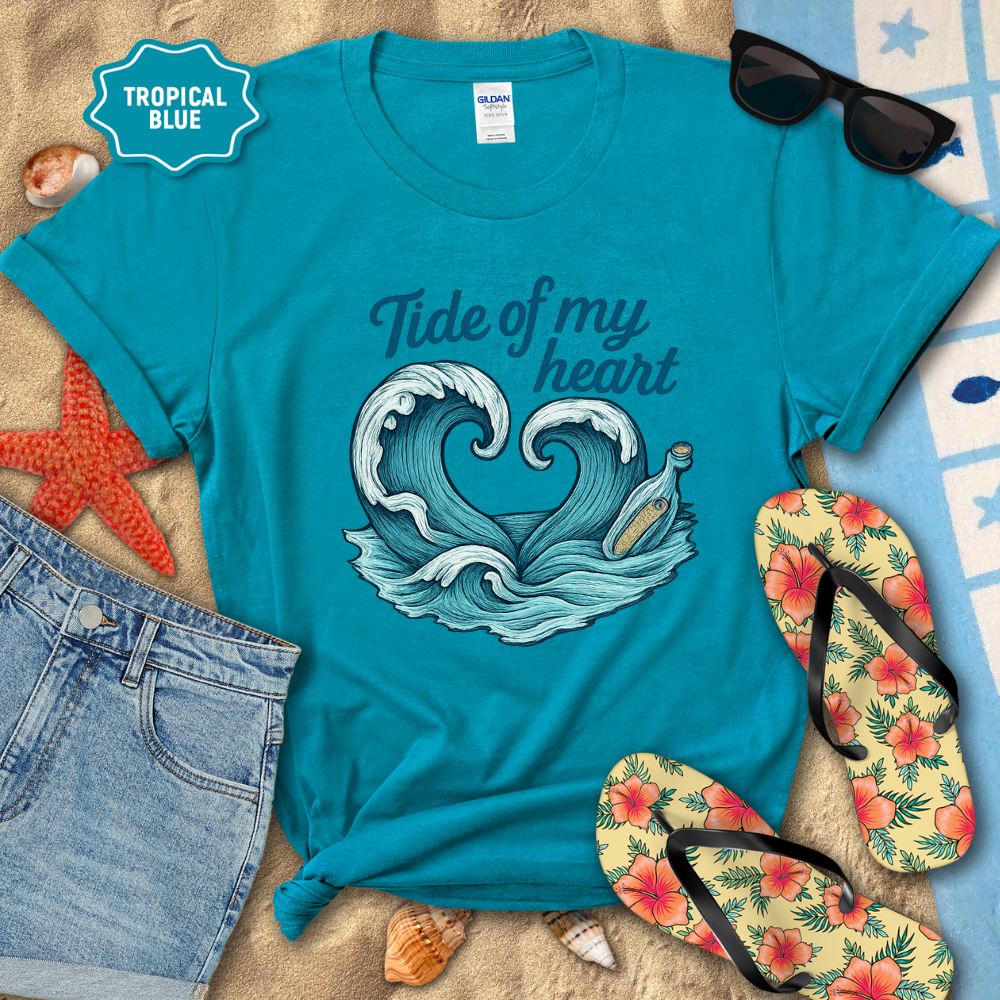 Blue t-shirt with wave design and text 'Tide of my heart' on a beach-themed background.