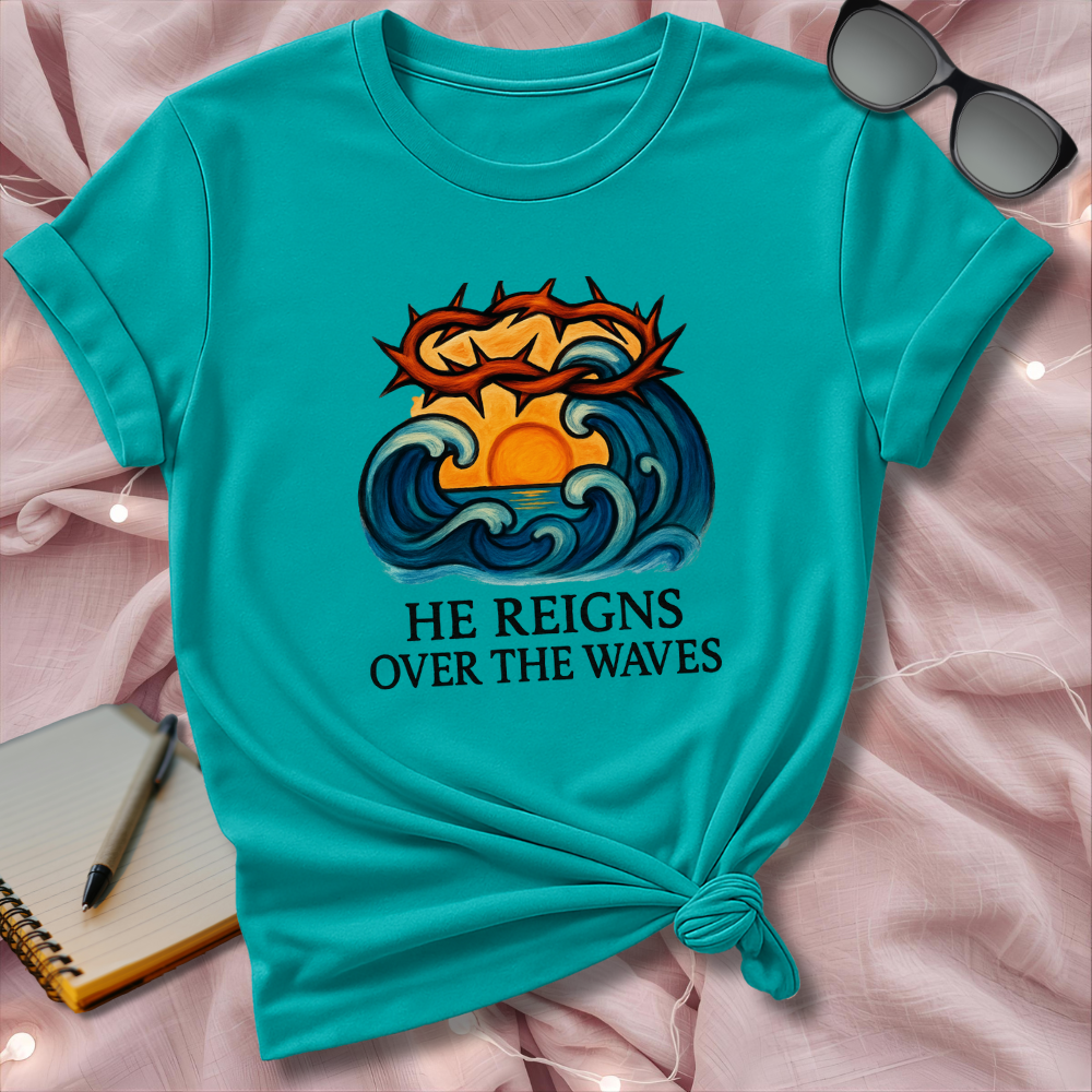 Turquoise t-shirt with a graphic design and text on a pink surface